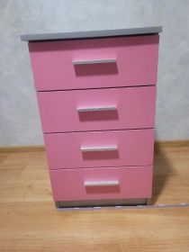 Komoda różowo-szara z szufladami.