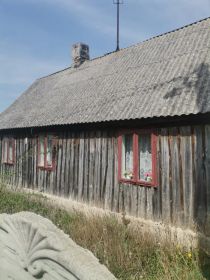 Działka 7a z drewnianym domem i budynkiem gospodarczym