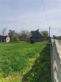 Działka 7a z drewnianym domem i budynkiem gospodarczym